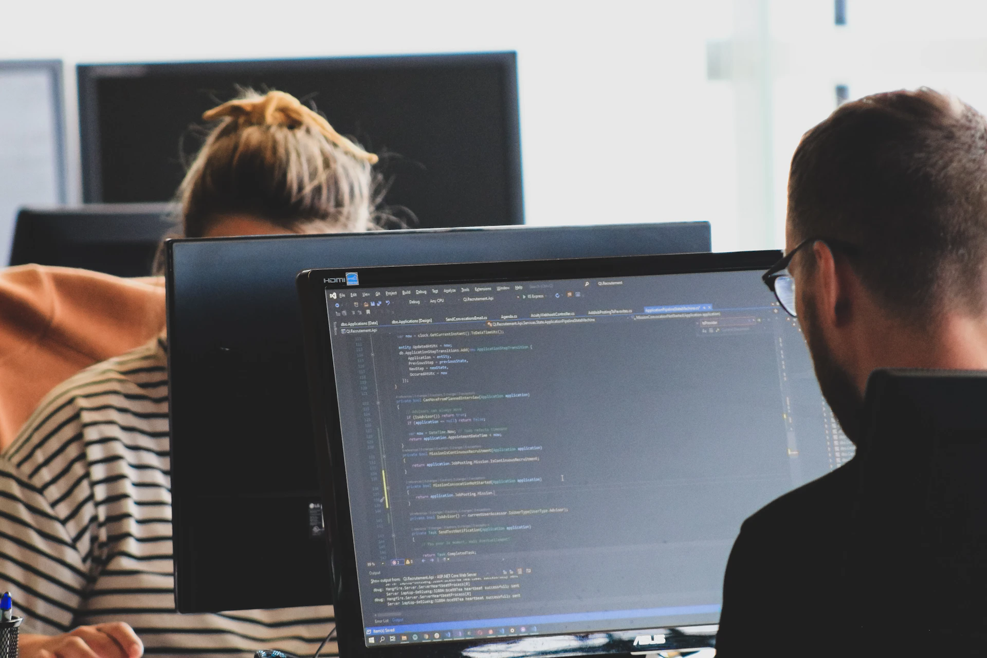 Developers working together at computer monitors